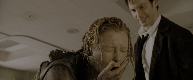 Medium shot frame from Constantine — standing, room, hand