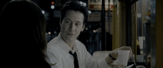 Medium shot frame from Constantine — sitting, table, street