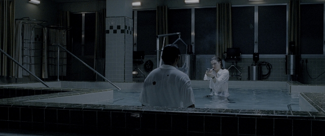 Wide shot frame from Constantine — standing, room, dialogue