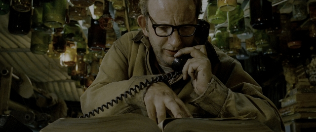 Wide shot frame from Constantine — sitting, room, table