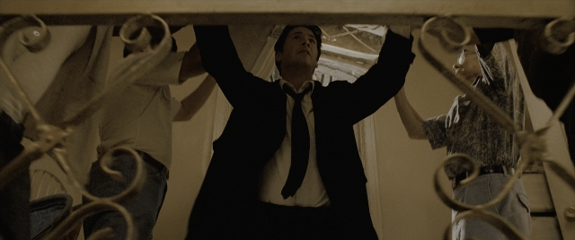 Wide shot frame from Constantine — standing, room, suit