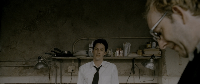 Wide shot frame from Constantine — standing, kitchen, tie