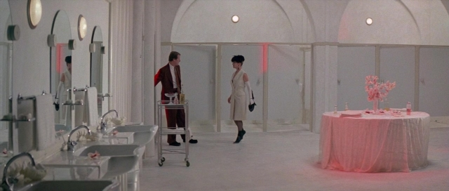 Wide shot frame from The Cook, the Thief, His Wife & Her Lover — standing, table, dialogue