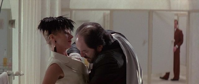 Wide shot frame from The Cook, the Thief, His Wife & Her Lover — door, mirror, kiss