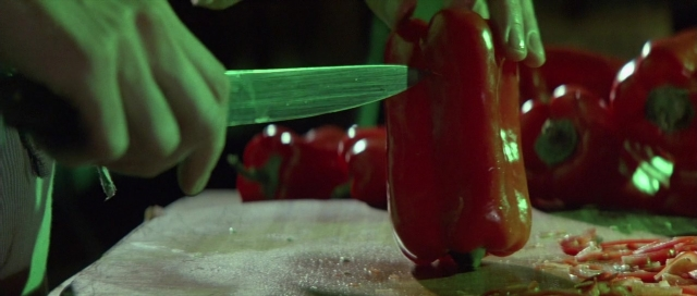 Medium shot frame from The Cook, the Thief, His Wife & Her Lover — kitchen, hand, knife