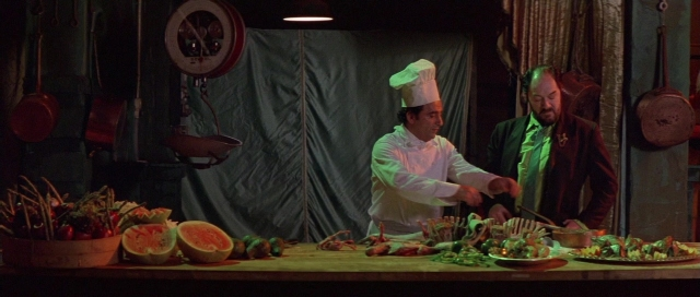Wide shot frame from The Cook, the Thief, His Wife & Her Lover — standing, plate, table
