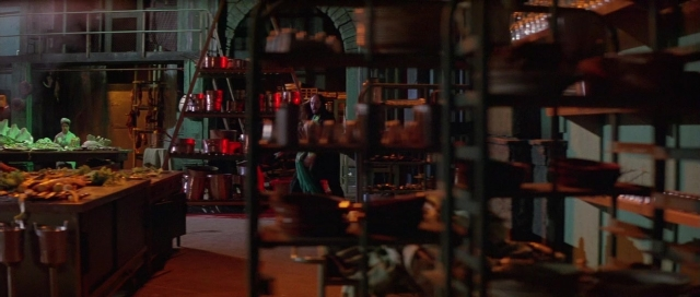 Wide shot frame from The Cook, the Thief, His Wife & Her Lover — room, table, kitchen