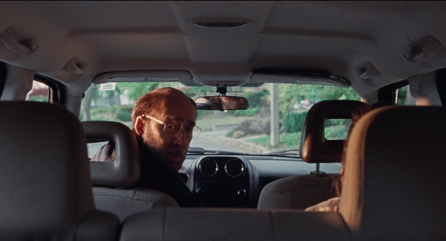 Frame from Dream Scenario — sitting, street, mirror