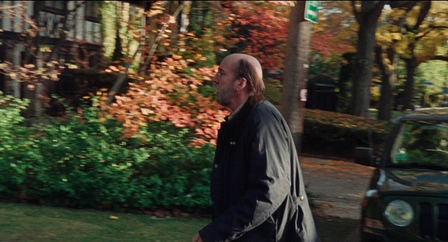 Wide shot frame from Dream Scenario — walking, street, car
