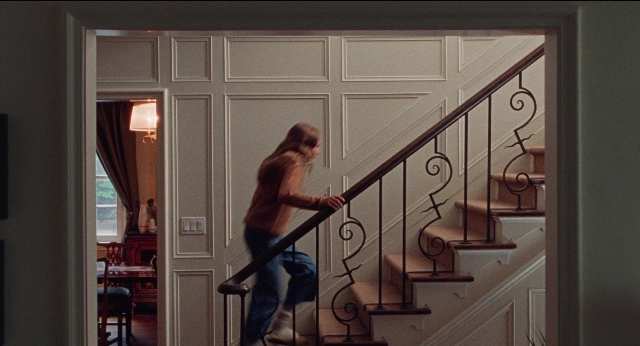 Frame from Dream Scenario — walking, room, table
