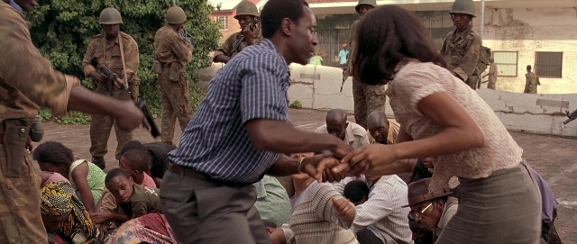 Frame from Hotel Rwanda — sitting, standing, street