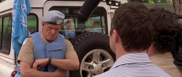 Wide shot frame from Hotel Rwanda — standing, hat, uniform