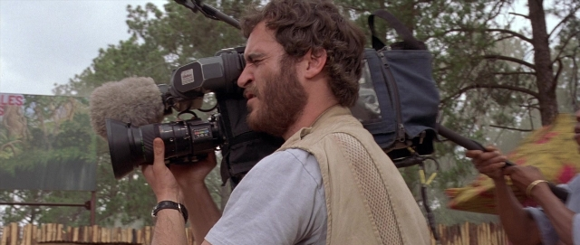 Wide shot frame from Hotel Rwanda — walking, beard, face