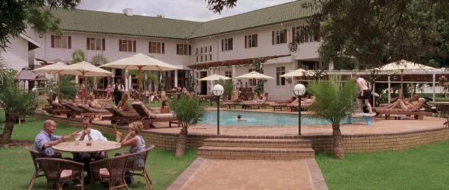 Wide shot frame from Hotel Rwanda — sitting, table, dialogue