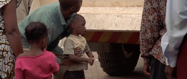 Wide shot frame from Hotel Rwanda — standing, street, person
