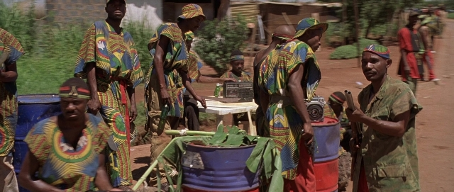 Wide shot frame from Hotel Rwanda — standing, table, person