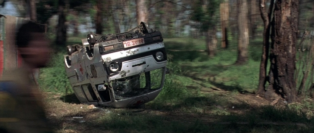 Wide shot frame from Hotel Rwanda — car, bird, forest