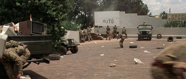 Wide shot frame from Hotel Rwanda — standing, street, wheel