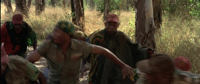 Wide shot frame from Hotel Rwanda — shirt, bag, forest