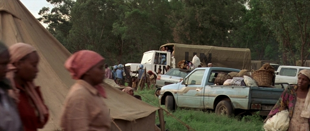 Wide shot frame from Hotel Rwanda — car, tent, wheel