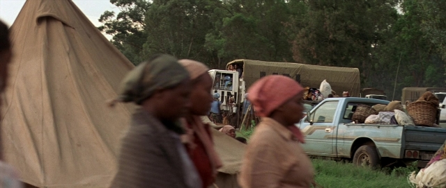 Wide shot frame from Hotel Rwanda — bed, tent, wheel