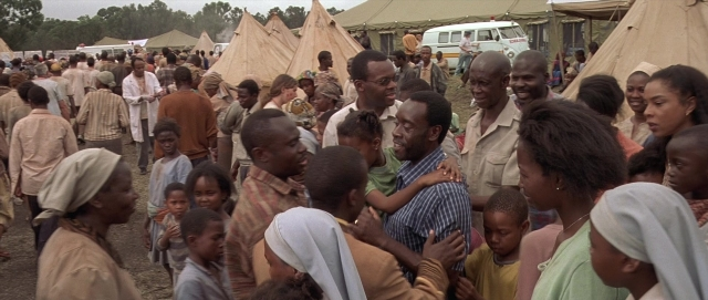 Wide shot frame from Hotel Rwanda — street, person, human face