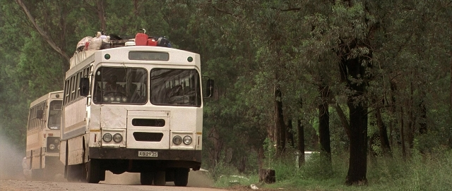 Wide shot frame from Hotel Rwanda — sitting, plate, street