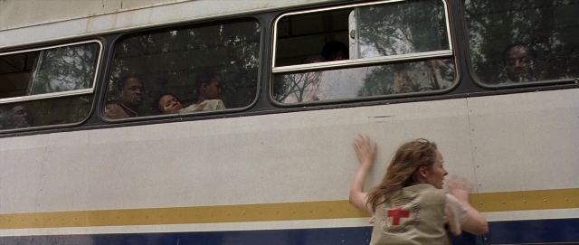 Wide shot frame from Hotel Rwanda — standing, shirt, hair