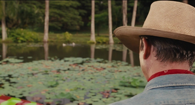 Frame from Jurassic Park — standing, hat, water