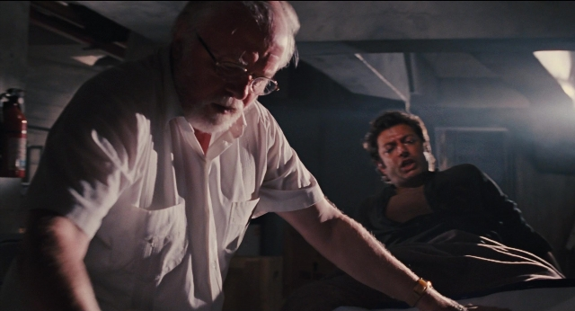 Wide shot frame from Jurassic Park — standing, room, bed