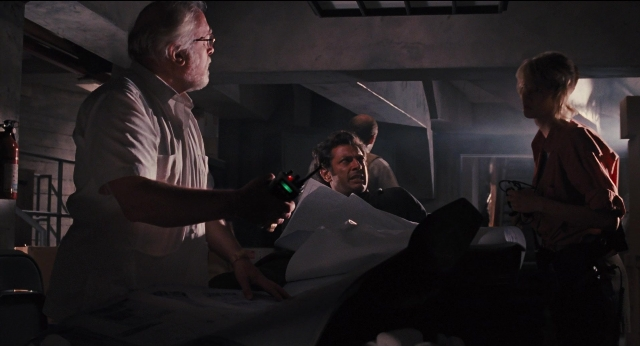 Wide shot frame from Jurassic Park — room, bed, hand