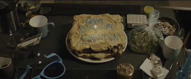 Wide shot frame from Kingsman: The Golden Circle — plate, table, bag