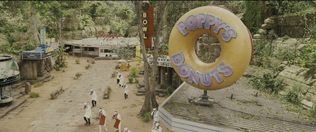 Wide shot frame from Kingsman: The Golden Circle — walking, doughnut, person