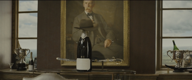 Wide shot frame from Kingsman: The Golden Circle — sitting, table, hat