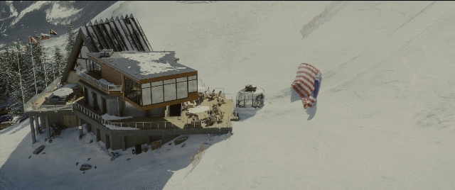Wide shot frame from Kingsman: The Golden Circle — flag, snow, window