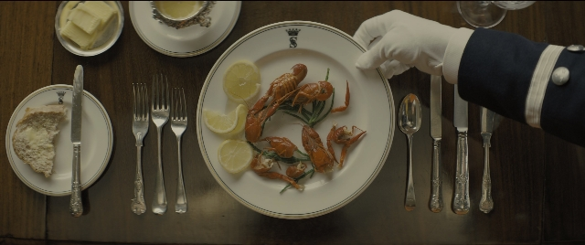 Medium shot frame from Kingsman: The Golden Circle — plate, table, hand