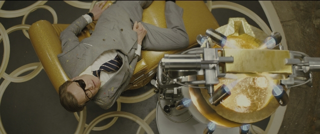 Wide shot frame from Kingsman: The Golden Circle — suit, tie, chair