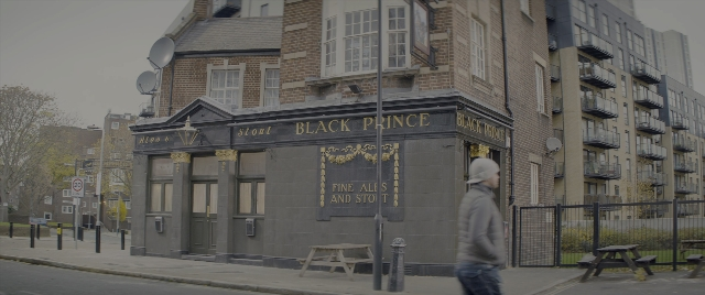Wide shot frame from Kingsman: The Secret Service — walking, table, street