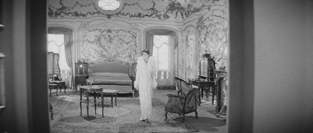 Wide shot frame from L'année dernière à Marienbad — room, table, bed