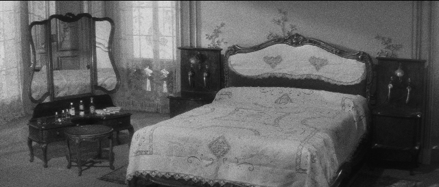 Wide shot frame from L'année dernière à Marienbad — room, bed, mirror