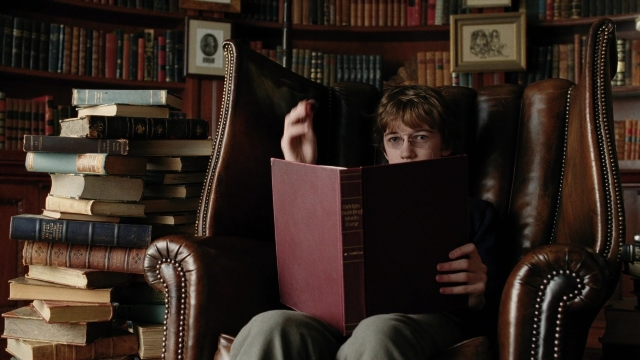 Wide shot frame from A Series of Unfortunate Events — sitting, book, face