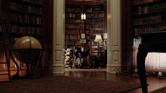 Wide shot frame from A Series of Unfortunate Events — sitting, book, room