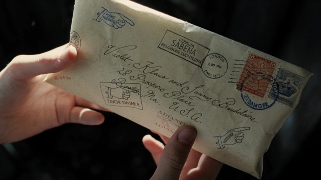 Frame from A Series of Unfortunate Events — hand, bird, envelope