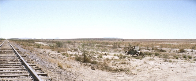 Frame from There Will Be Blood — car, train, wheel