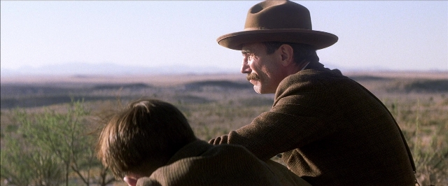 Frame from There Will Be Blood — sitting, hat, mustache
