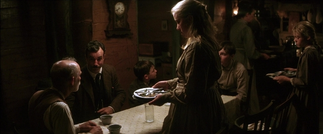 Wide shot frame from There Will Be Blood — sitting, plate, room