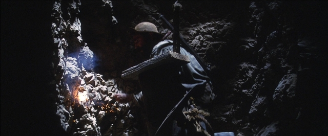 Wide shot frame from There Will Be Blood — standing, hat, fire