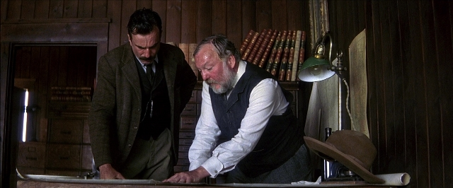 Wide shot frame from There Will Be Blood — room, table, door