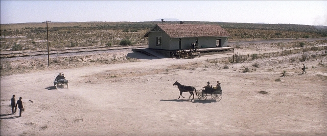 Frame from There Will Be Blood — sitting, walking, street