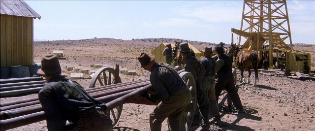 Wide shot frame from There Will Be Blood — pipe, person